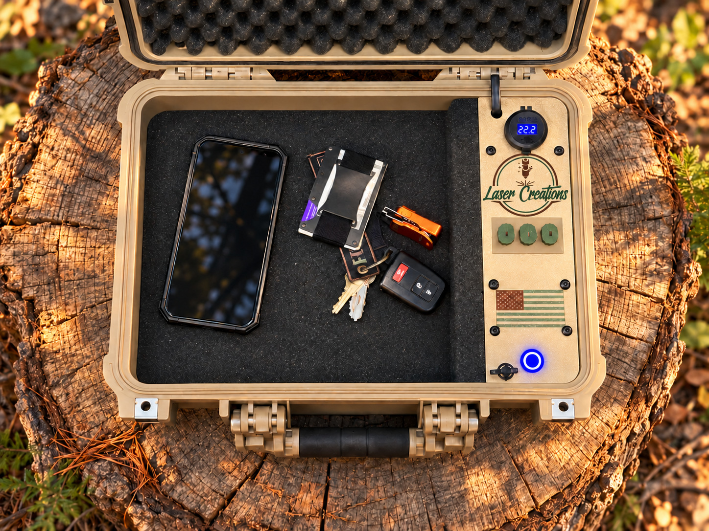 Open TANK case holding a phone, wallet, and keys in the foam-lined storage area beside the control panel